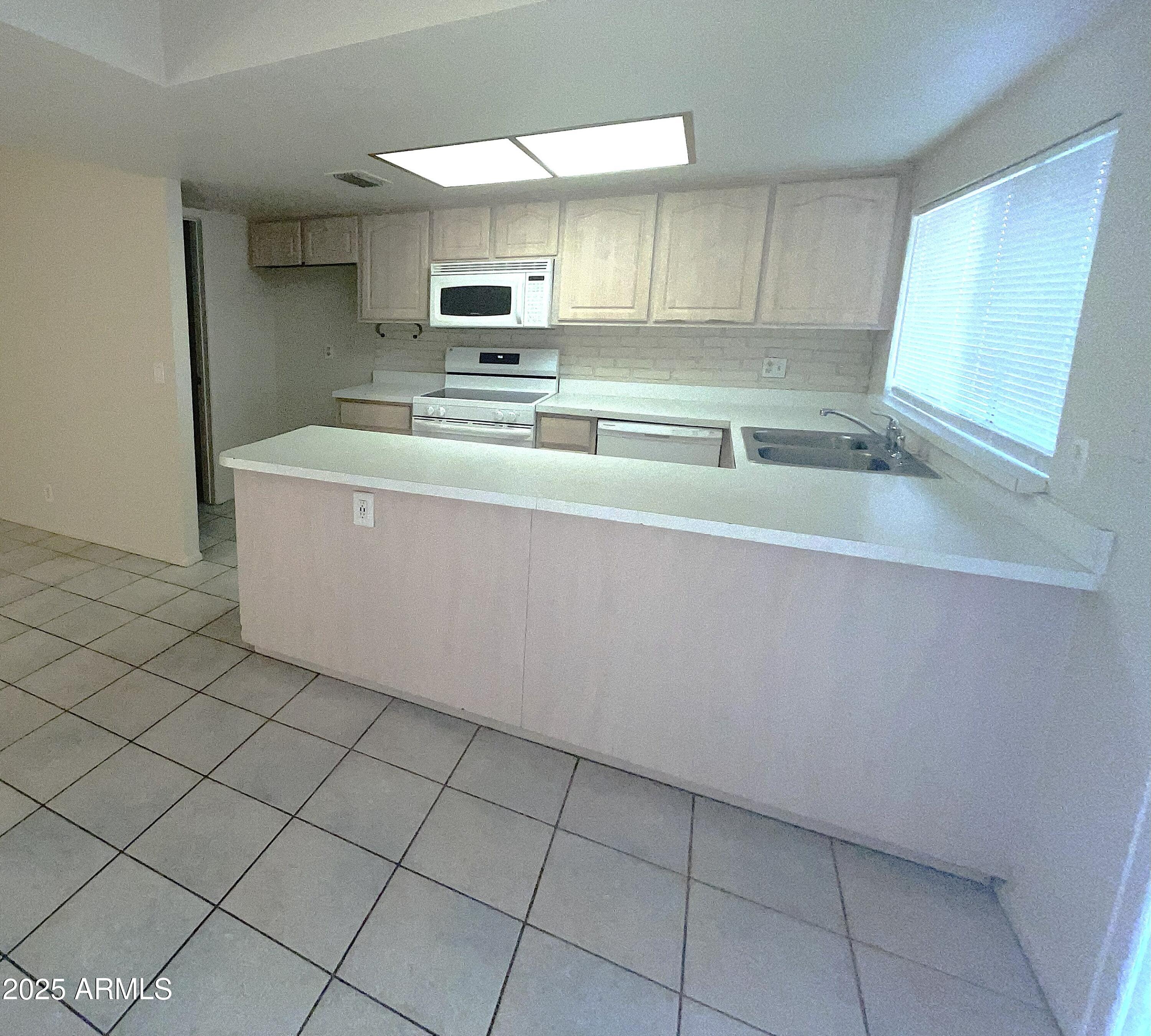 17811 North 29th Drive Phoenix, AZ 85053 - Photo 3 of 14 a kitchen with stainless steel appliances a sink stove and cabinets