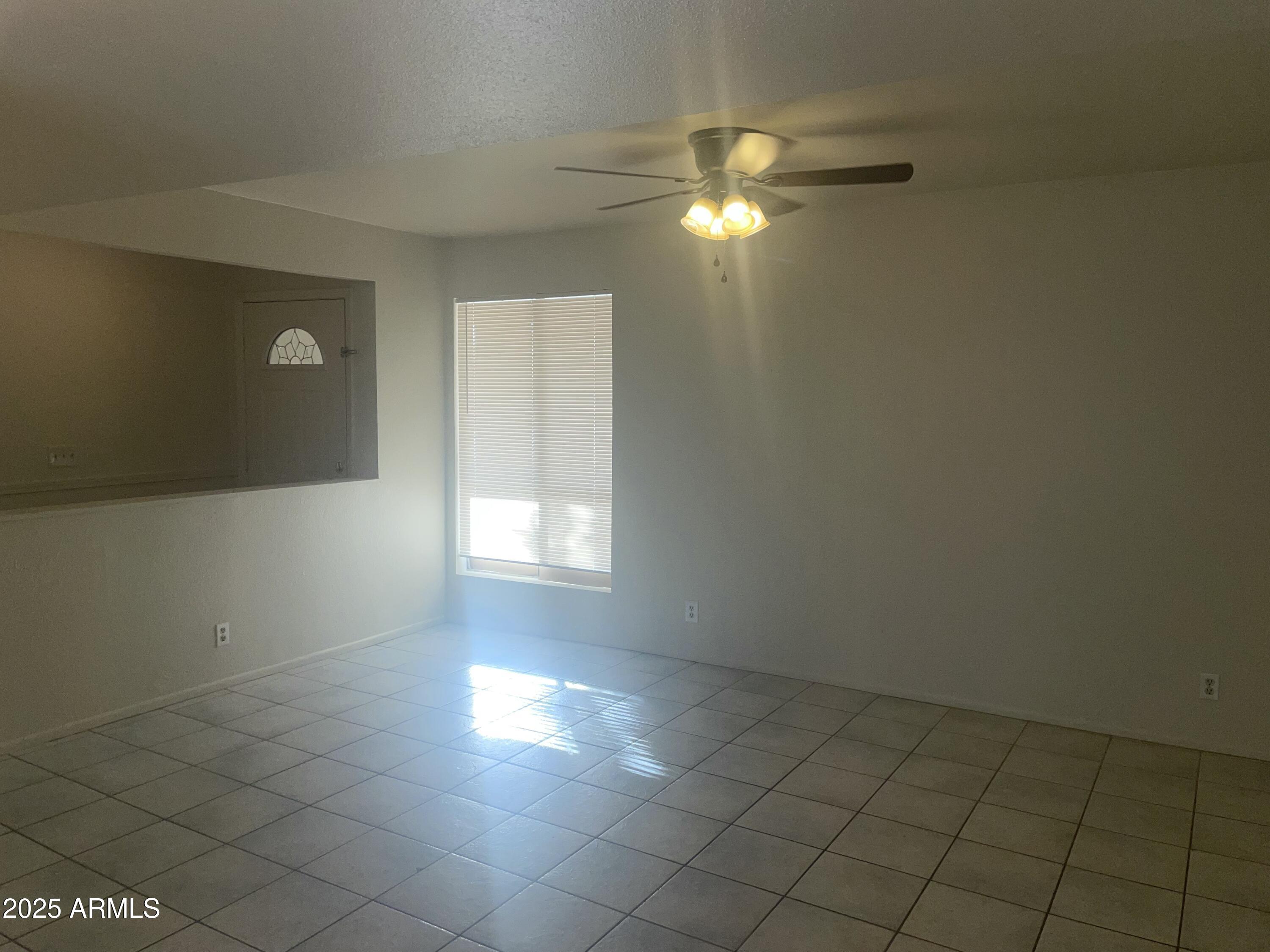 17811 North 29th Drive Phoenix, AZ 85053 - Photo 5 of 14 en empty room with windows and fan