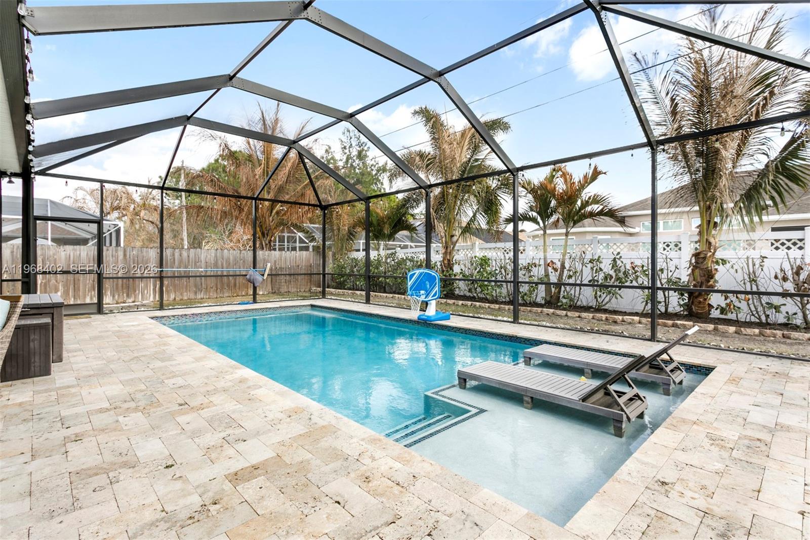 1773 Southwest Palermo Road Port St. Lucie, FL 34987 - Photo 33 of 50 Custom travertine decking surrounds this crystal blue pool oasis designed for year round enjoyment! The expansive screened lanai offers plenty of room to lounge, and entertain! A true extention of the home's living space!