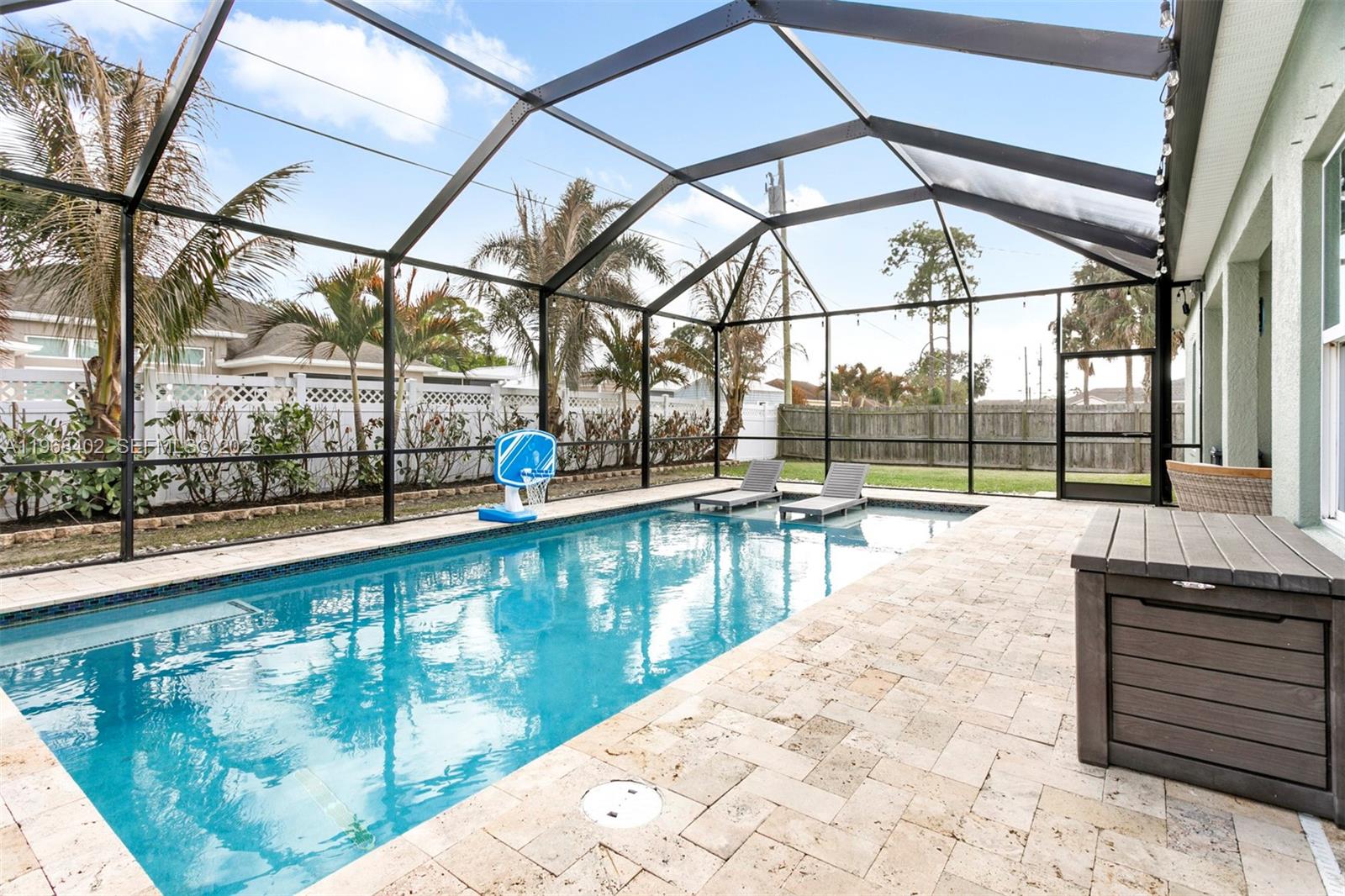 1773 Southwest Palermo Road Port St. Lucie, FL 34987 - Photo 35 of 50 Custom travertine decking surrounds this crystal blue pool oasis designed for year round enjoyment! The expansive screened lanai offers plenty of room to lounge, and entertain! A true extention of the home's living space!
