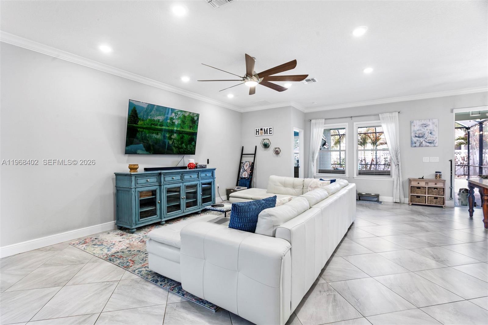 1773 Southwest Palermo Road Port St. Lucie, FL 34987 - Photo 9 of 50 Living room/kichen/dining room. Wide open floorplan featuring large neutral tile flooring, high hat lighting, newer fan/light, views to pool/patio!