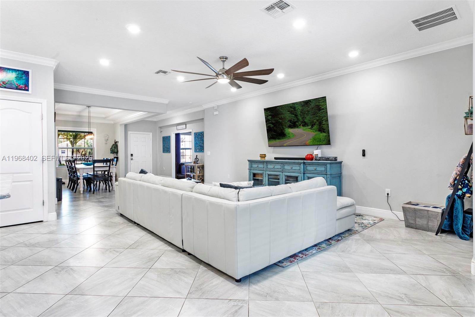 1773 Southwest Palermo Road Port St. Lucie, FL 34987 - Photo 10 of 50 Living room/kichen/dining room. Wide open floorplan featuring large neutral tile flooring, high hat lighting, newer fan/light, views to pool/patio!