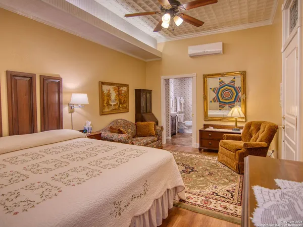 a spacious bedroom with a bed and dresser