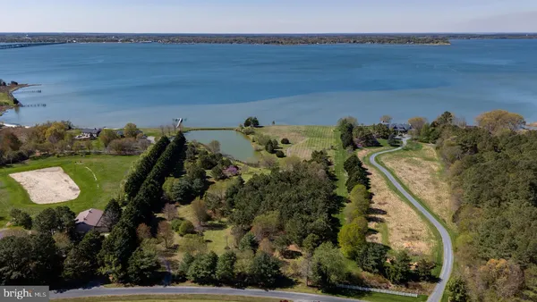 an aerial view of a house with a yard and lake view
