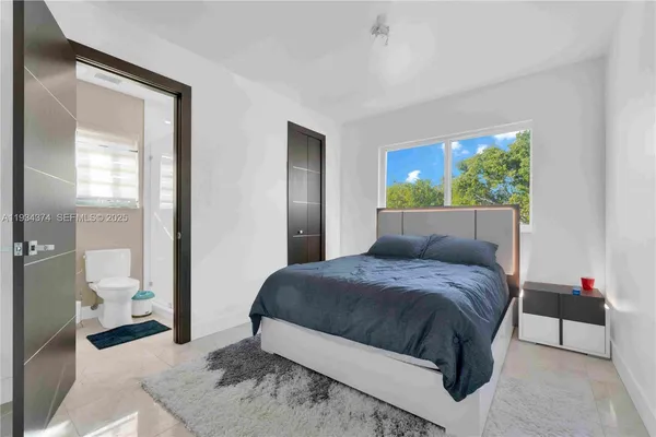 a bedroom with a bed and a large window