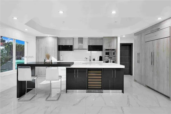 a kitchen with kitchen island a sink appliances and a large window