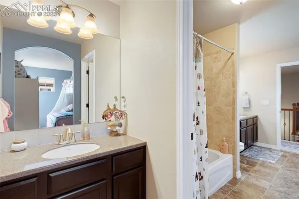 a bathroom with a sink a toilet a mirror a vanity and shower