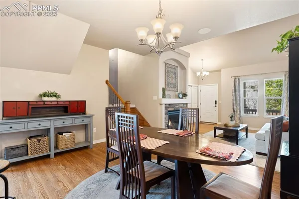 a view of a dining room with furniture a chandelier and wooden floor