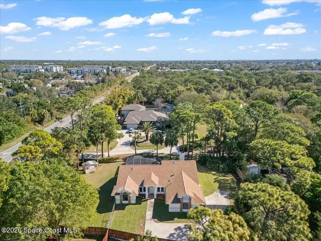 an aerial view of residential houses with outdoor space and trees