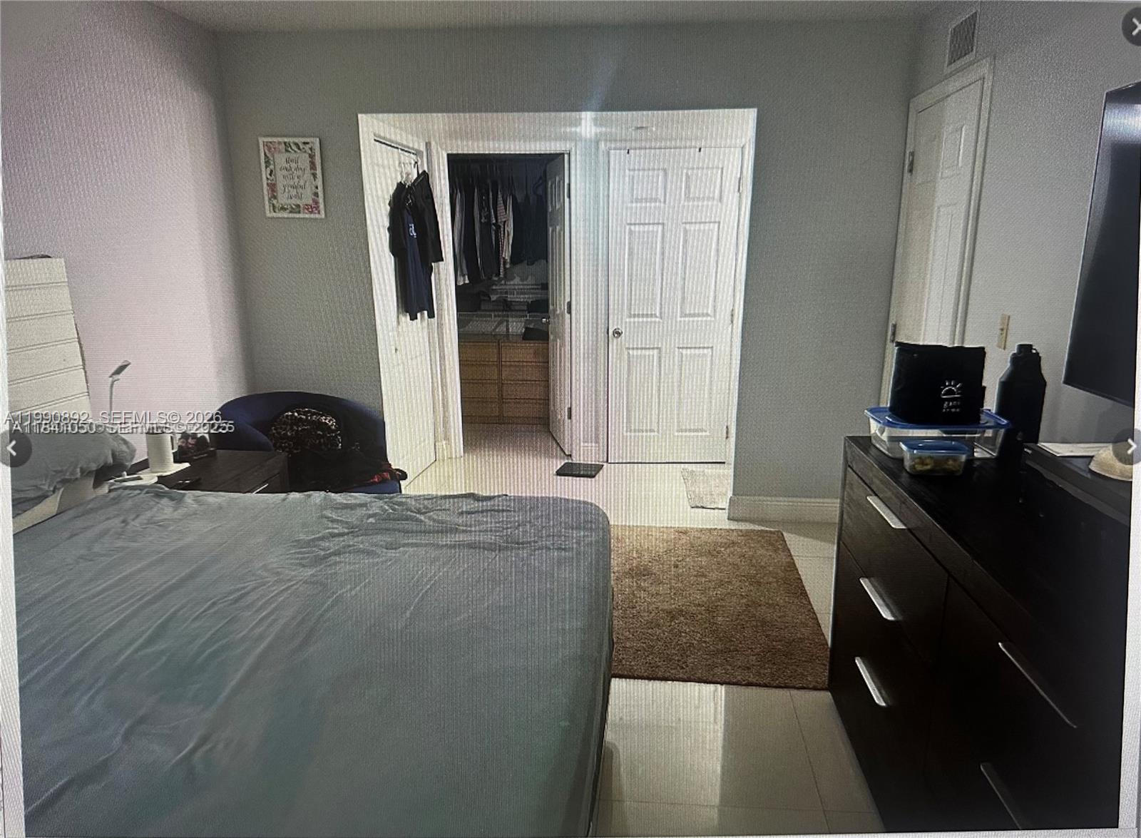 13810 Southwest 112th Street, Unit 106 Miami, FL 33186 - Photo 11 of 20 a bedroom with a bed and a dresser