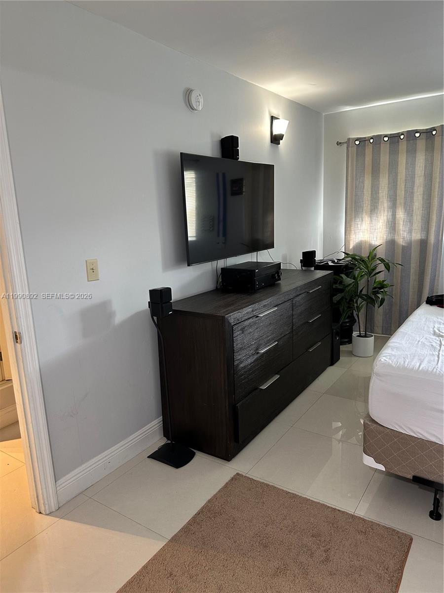 13810 Southwest 112th Street, Unit 106 Miami, FL 33186 - Photo 13 of 20 a living room with furniture and a flat screen tv