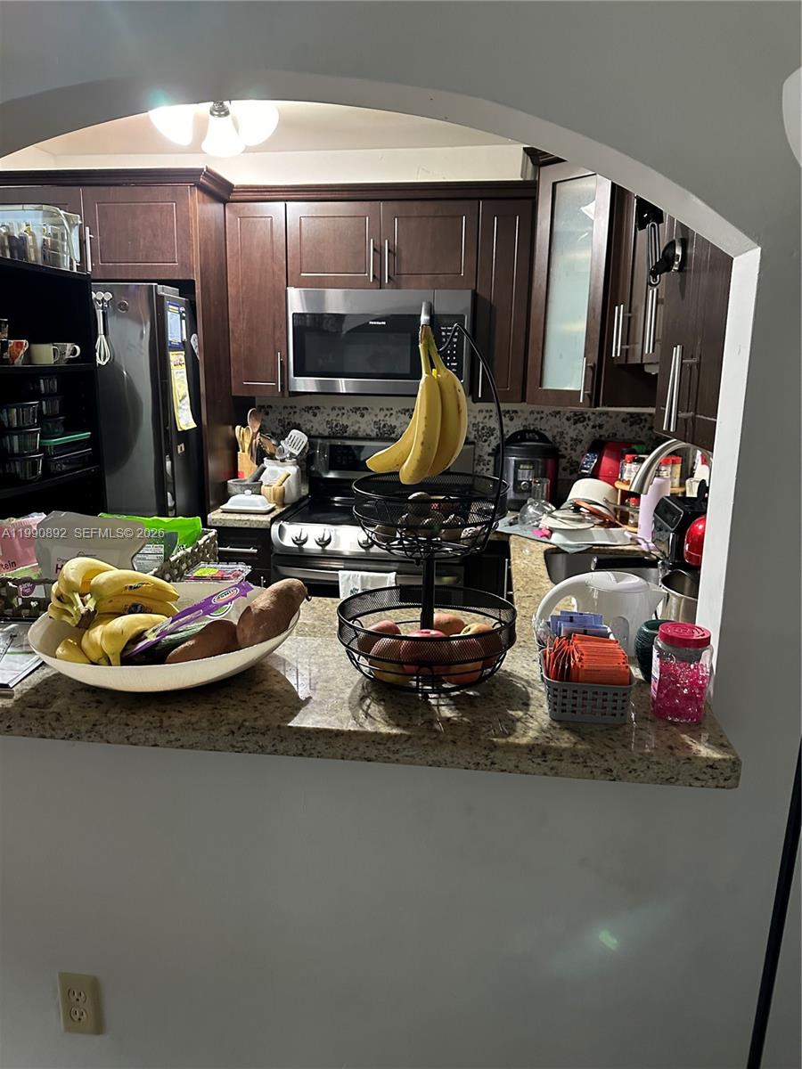 13810 Southwest 112th Street, Unit 106 Miami, FL 33186 - Photo 6 of 20 a view of a kitchen with kitchen island stainless steel appliances a refrigerator and a sink