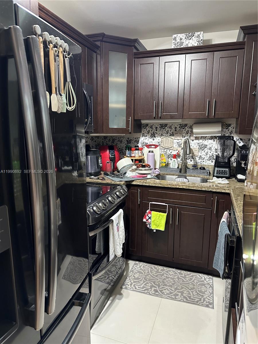 13810 Southwest 112th Street, Unit 106 Miami, FL 33186 - Photo 8 of 20 a kitchen with refrigerator and cabinets