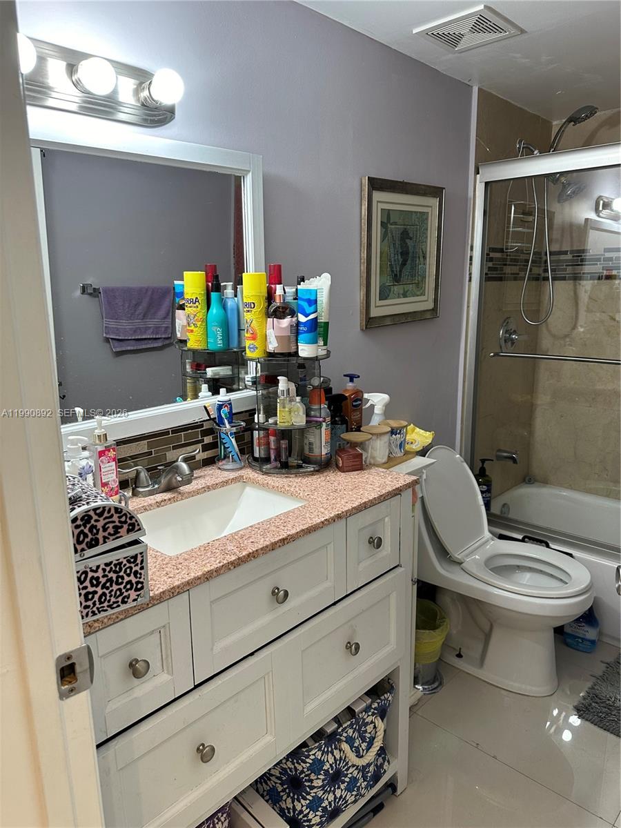 13810 Southwest 112th Street, Unit 106 Miami, FL 33186 - Photo 10 of 20 a bathroom with a sink a toilet and a mirror