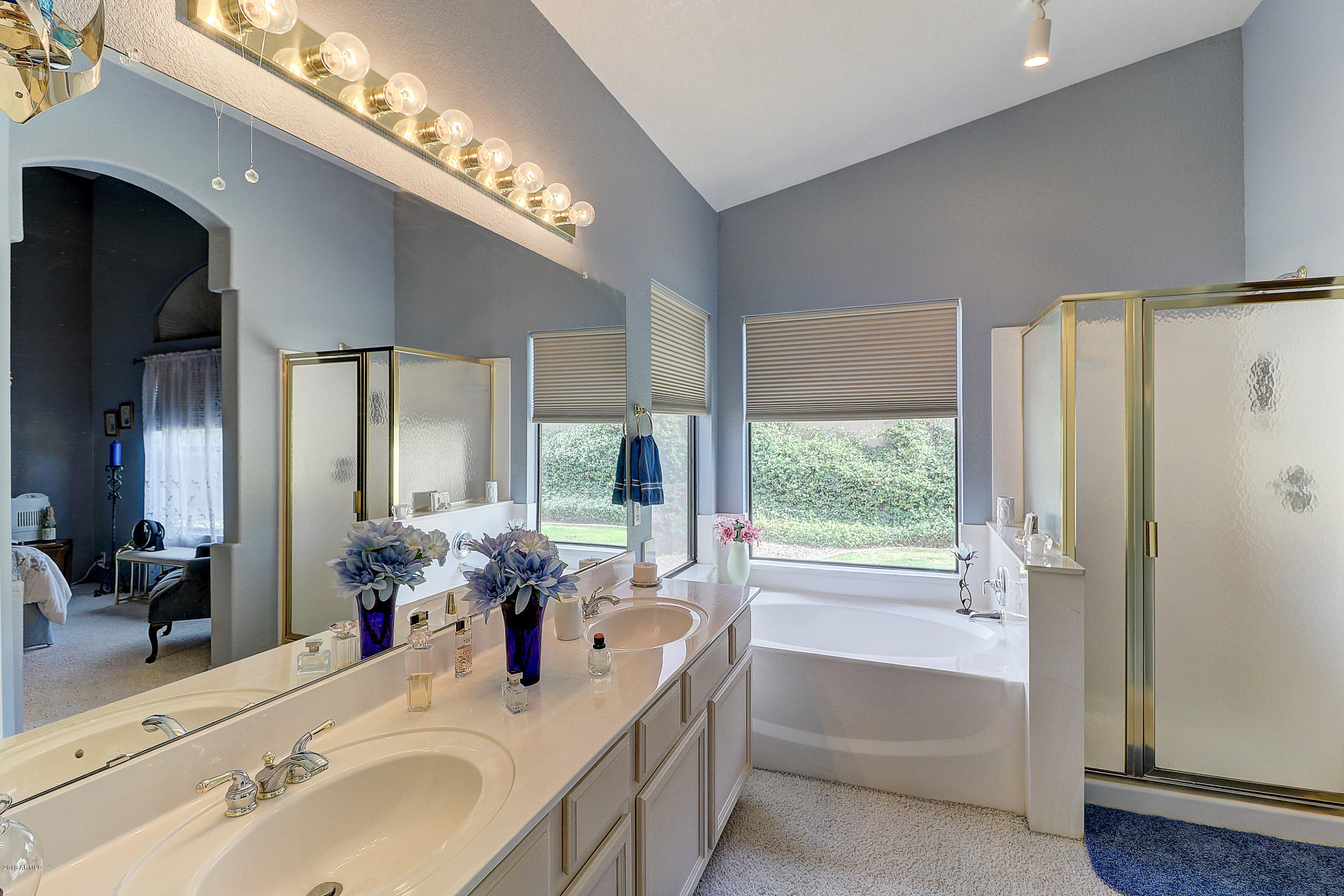 2101 East Escuda Road Phoenix, AZ 85024 - Photo 24 of 31 a bathroom with a tub a double vanity sink a large mirror and a bathtub next to a window