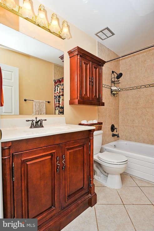 8901 Spur Road Springfield, VA 22153 - Photo 17 of 30 a bathroom with a toilet a sink a mirror and vanity