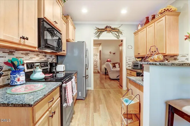 a kitchen with stainless steel appliances granite countertop a sink stove and cabinets