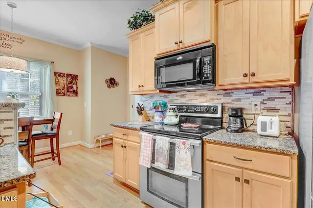a kitchen with stainless steel appliances granite countertop a stove a sink and a microwave