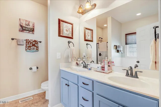 a bathroom with a sink a toilet a mirror and shower