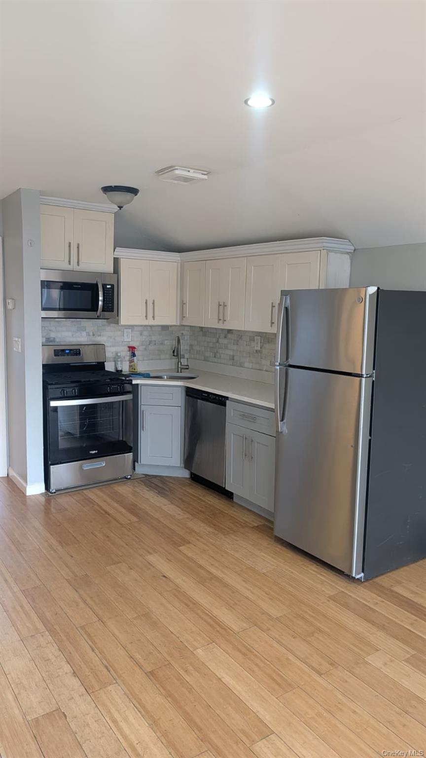 134-15 228th Street, Unit 2 Queens, NY 11413 - Photo 11 of 16 a kitchen with stainless steel appliances granite countertop a refrigerator and a stove top oven