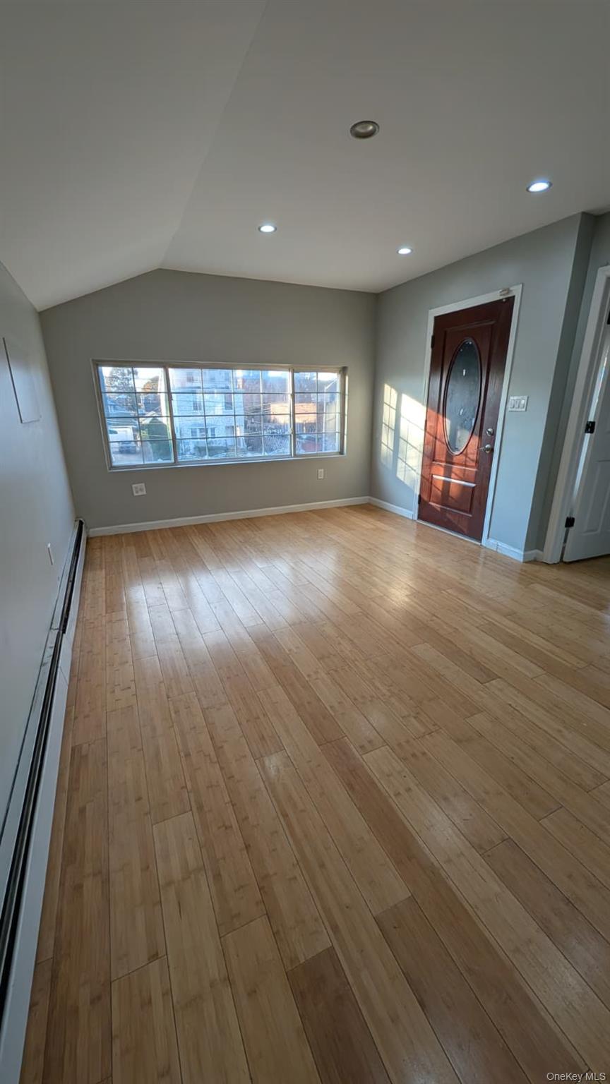 134-15 228th Street, Unit 2 Queens, NY 11413 - Photo 15 of 16 an empty room with wooden floor and windows