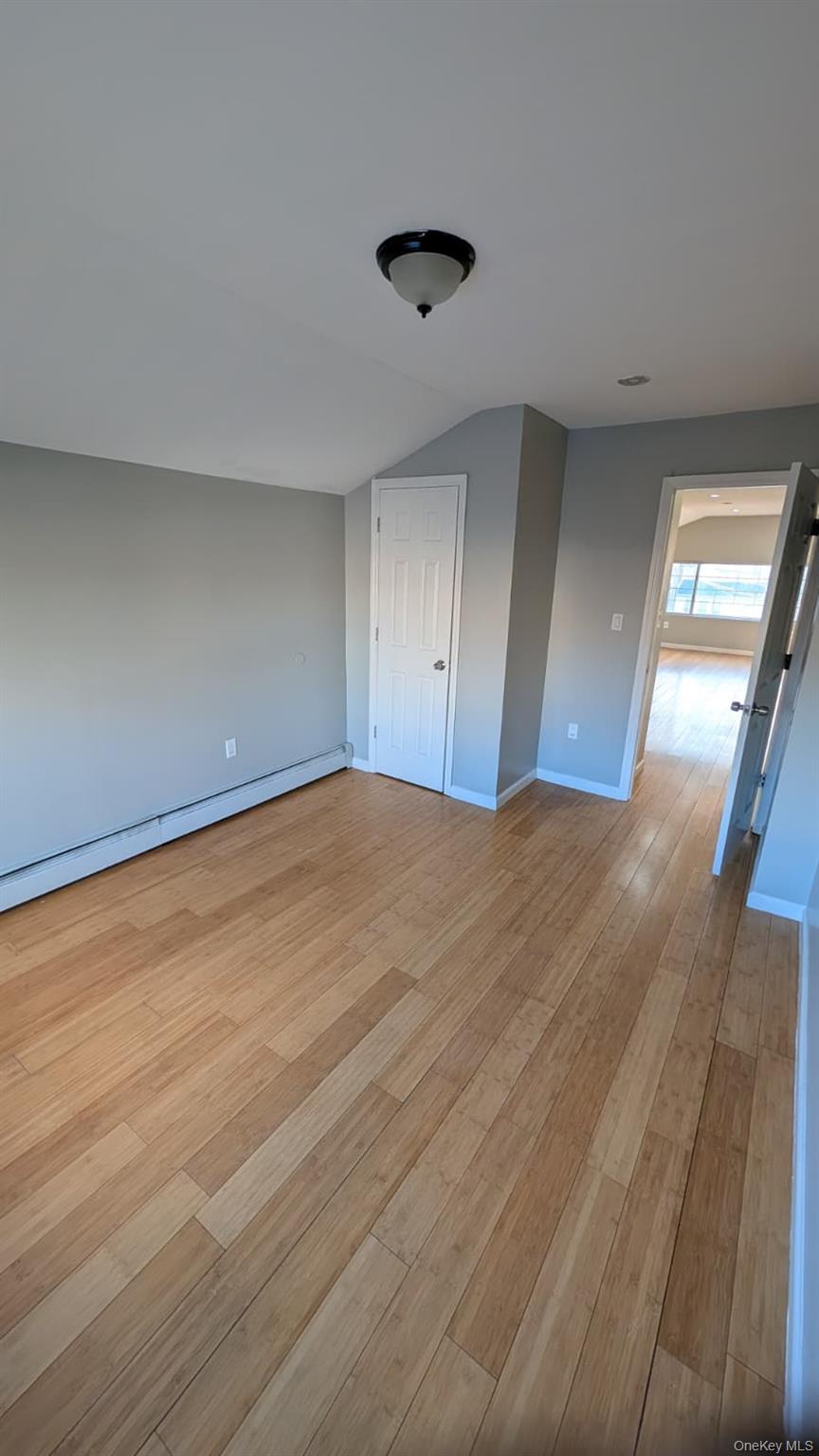 134-15 228th Street, Unit 2 Queens, NY 11413 - Photo 8 of 16 a view of an empty room with wooden floor