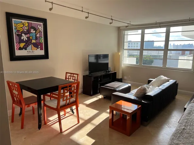 a dining room with furniture and a flat screen tv
