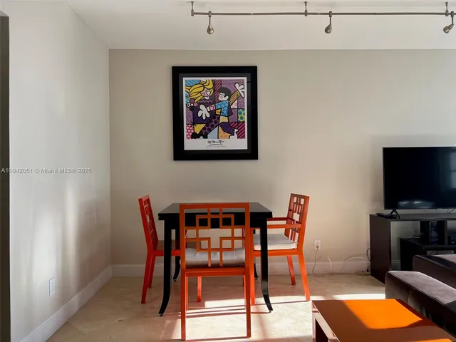 a living room with furniture a flat screen tv and a window