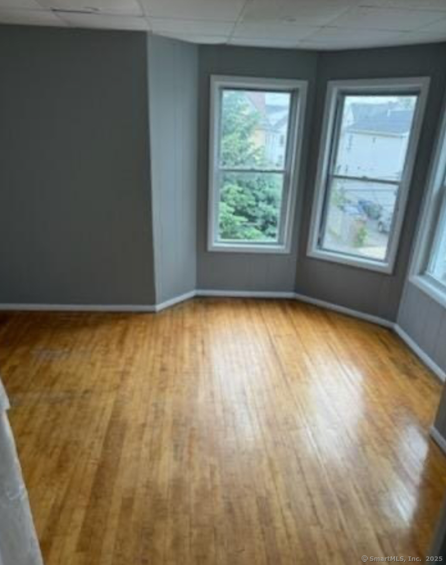 95 Center Street, Unit 2 Bridgeport, CT 06604 - Photo 3 of 4 wooden floor in an empty room with a window