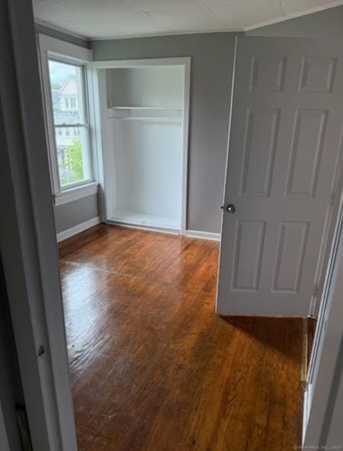 95 Center Street, Unit 2 Bridgeport, CT 06604 - Photo 4 of 4 a view of an empty room with wooden floor and a window
