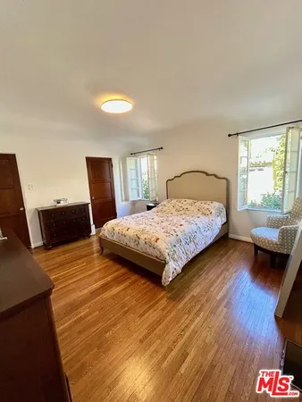 a bedroom with a bed rug and wooden floor