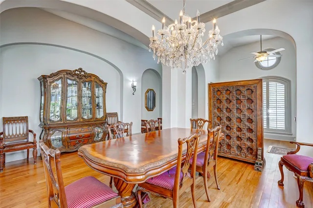 a dining room with furniture a chandelier and wooden floor
