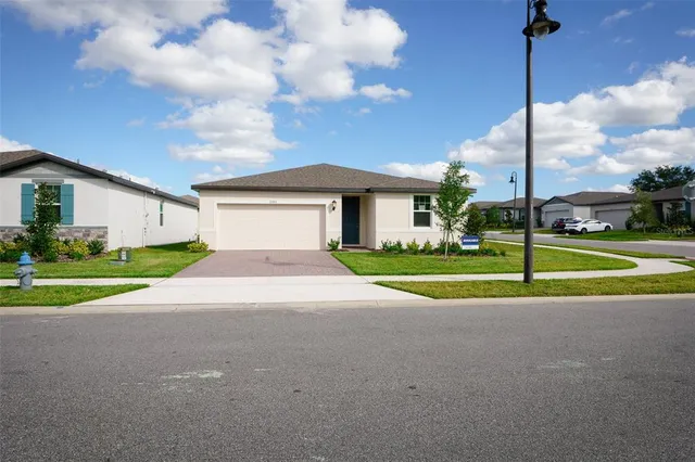 a view of a house with a big yard and palm trees