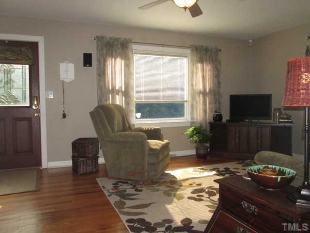 5507 Meadowbrook Road Raleigh, NC 27603 - Photo 13 of 25 The living room features hardwood flooring and has a ceiling fan with light fixture. Wonderful open space is nice and bright with a wonderful picture window looking into the front yard!