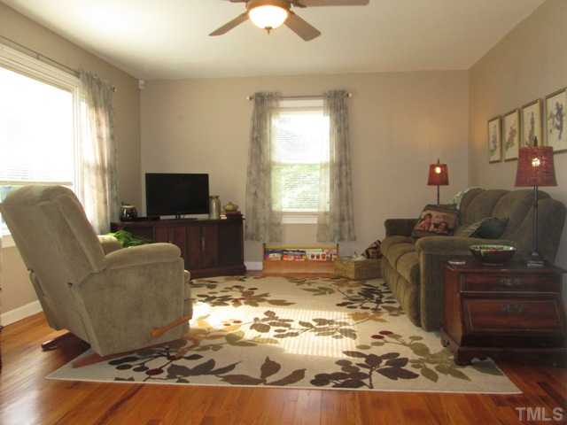 5507 Meadowbrook Road Raleigh, NC 27603 - Photo 16 of 25 Wonderful view of living room that shows the ceiling fan with light fixture, picture window that looks out to the front yard and another window on the side of home & there is plenty of space for your furniture and TV so you can enjoy the surround sound!