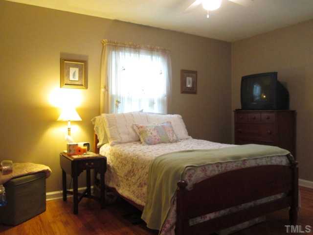 5507 Meadowbrook Road Raleigh, NC 27603 - Photo 21 of 25 Lovely and tastefully decorated master bedroom features hardwood floors and a ceiling fan with light fixture!