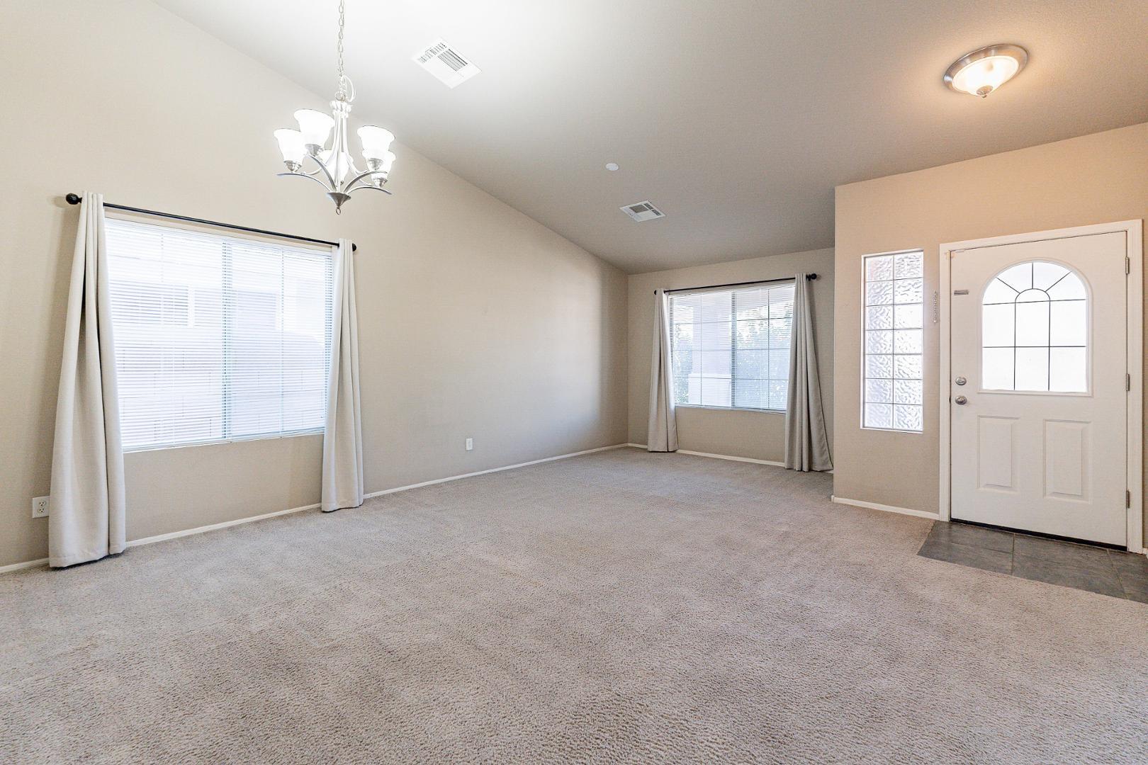 3713 East Utopia Road Phoenix, AZ 85050 - Photo 2 of 47 an empty room with chandelier and windows