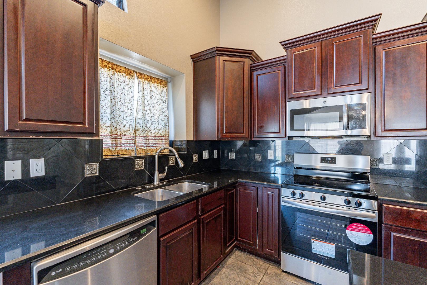 3713 East Utopia Road Phoenix, AZ 85050 - Photo 8 of 47 a kitchen with stainless steel appliances granite countertop a sink stove and microwave