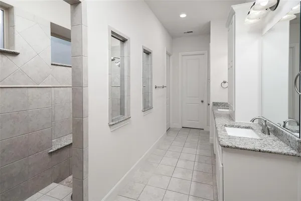 a bathroom with a granite countertop sink a mirror and a shower