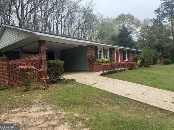 a front view of house with yard and trees in the background