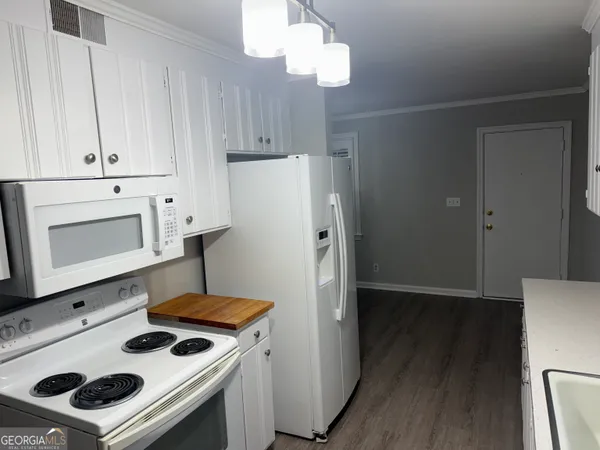 a kitchen with a refrigerator and a stove top oven