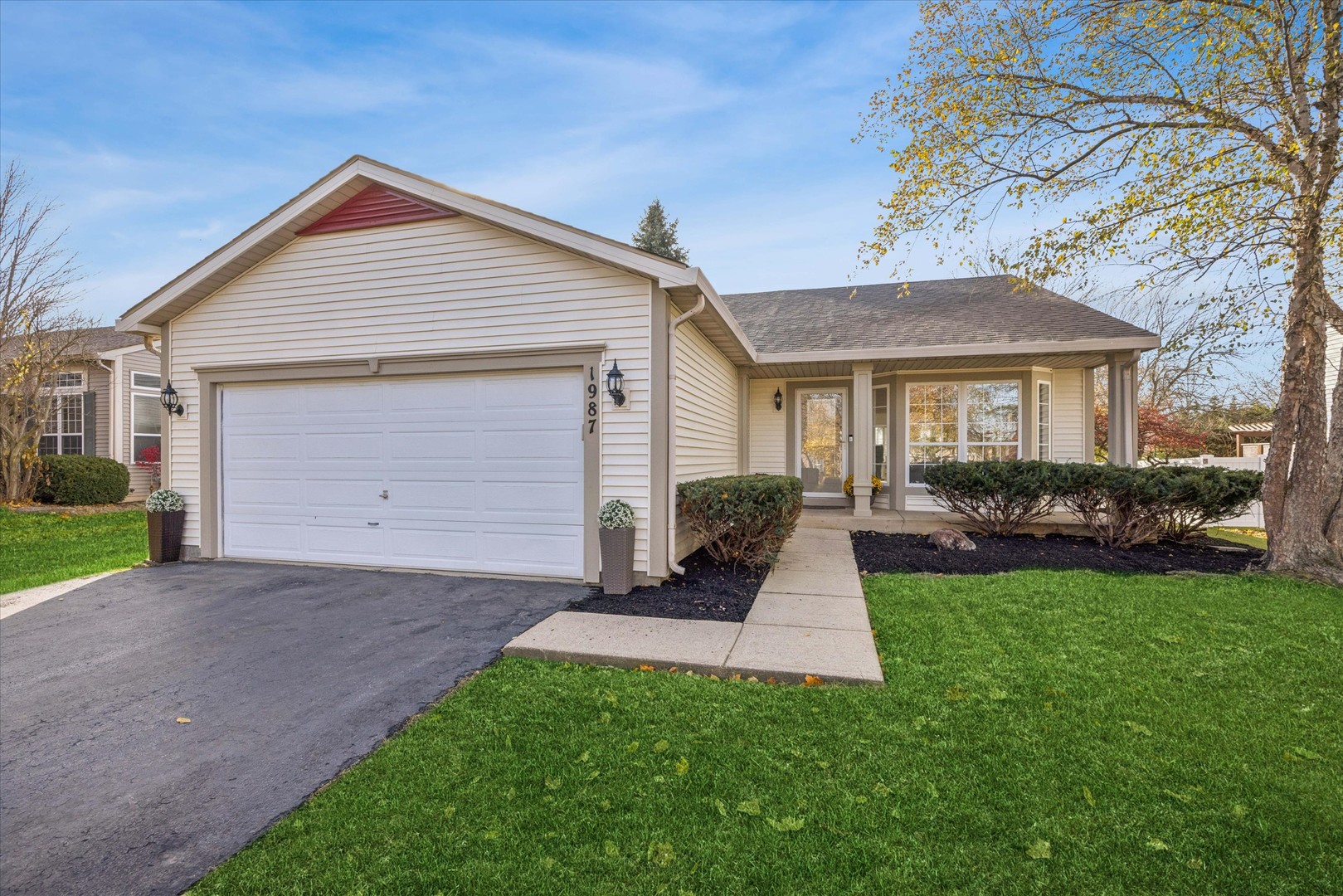a front view of a house with a yard and trees