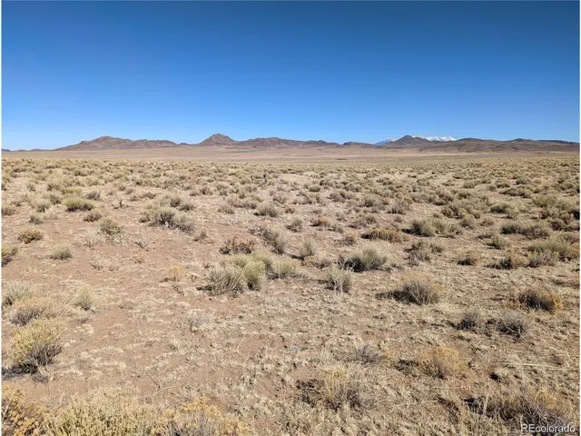a view of a large mountains with sunset in the background
