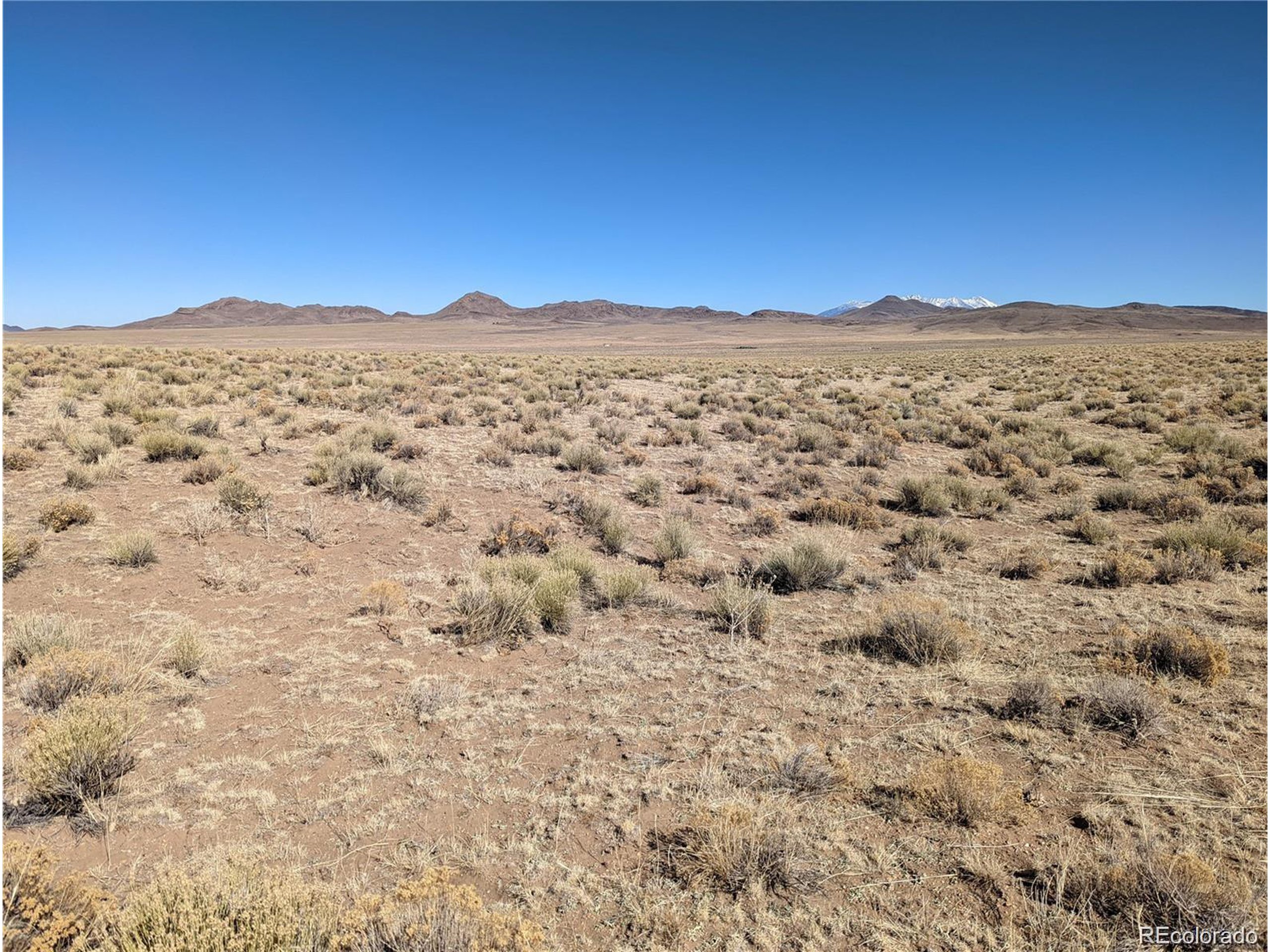 a view of a large mountains with sunset in the background