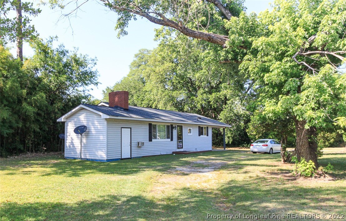 85 McIntyre Road Pinehurst, NC 28374 - Photo 20 of 20 a front view of a house with a garden and swimming pool