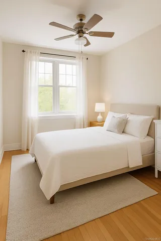 a bedroom with a large bed and a chandelier fan
