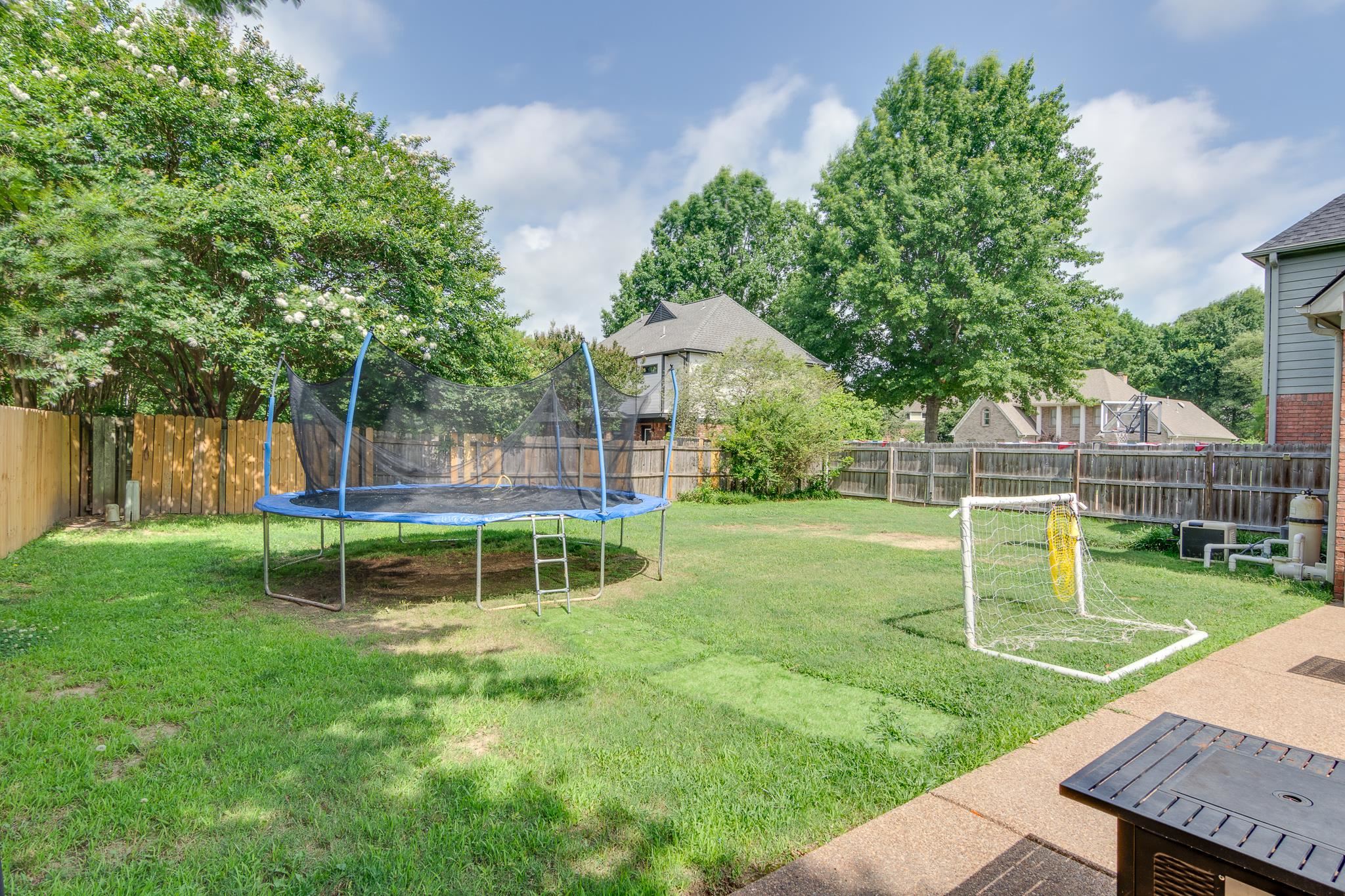 779 Early Earner Cove Collierville, TN 38017 - Photo 28 of 29 Expansive backyard featuring a privacy fence, mature trees, and a concrete patio