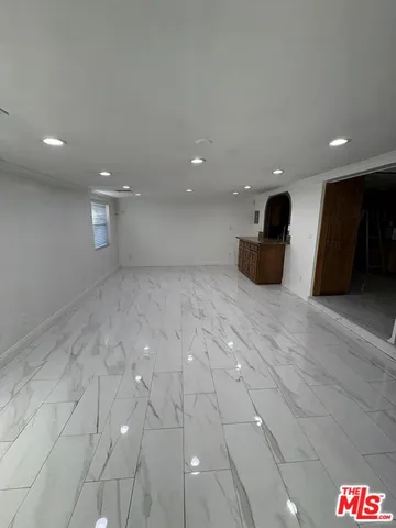 a view of a white house with a yard potted plants