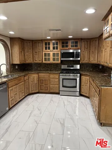 a kitchen with stainless steel appliances granite countertop a stove sink and cabinets