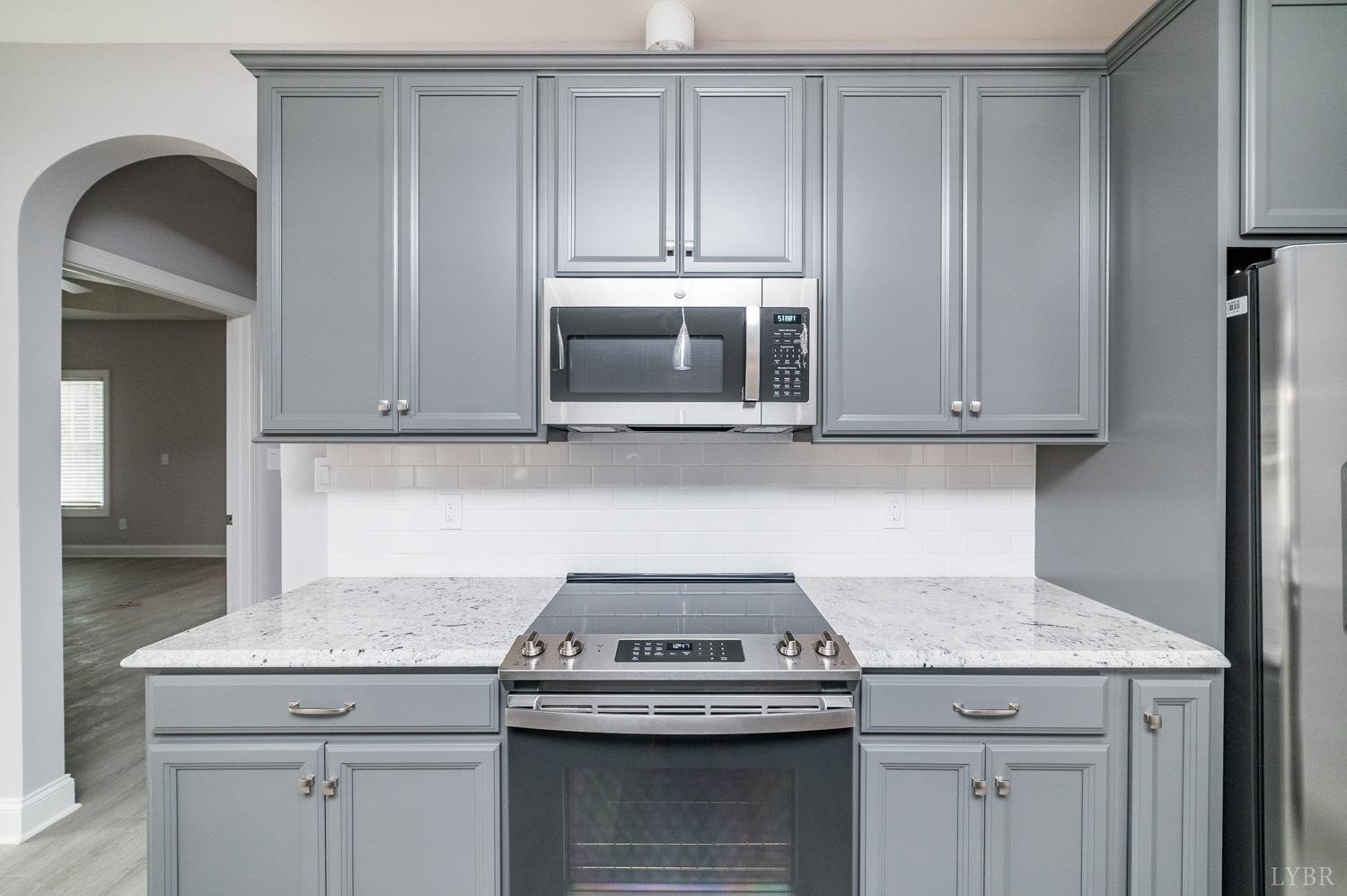 1051 Wills Way Forest, VA 24551 - Photo 5 of 49 a kitchen with granite countertop cabinets stove and microwave